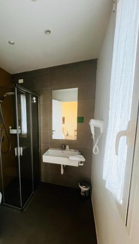 a bathroom with a sink and a shower and a mirror at Hotel Anversa Rimini in Rimini