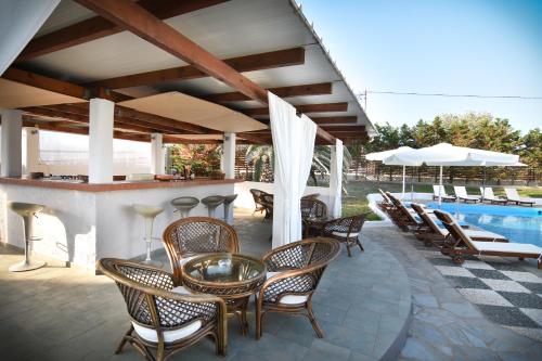 a patio with a bar and chairs and a pool at Hotel Melikari in Skiros