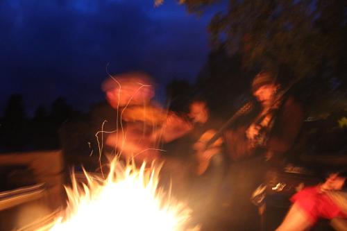 a group of people standing around a bonfire at night at Lövås Gård Koppera in Charlottenberg