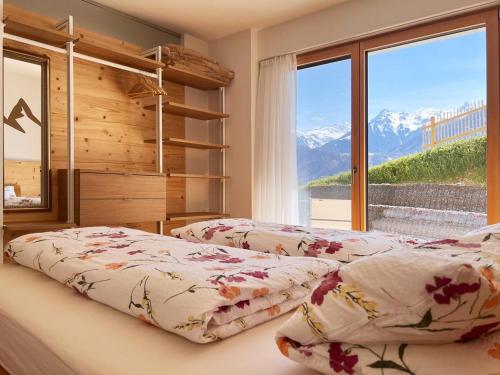 two beds in a bedroom with a view of mountains at Apartment Fidelia in Vandans