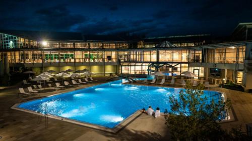 a large pool in front of a building at night at Altmühl Hideaway Apartment 1 in Treuchtlingen