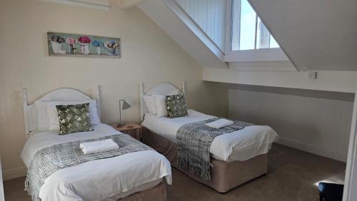 a bedroom with two beds and a window at Westfield House - Characterful 7 bedroom townhouse in Skipton