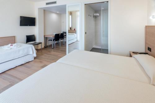a hotel room with a bed and a television at Aparthotel Marinada in Salou
