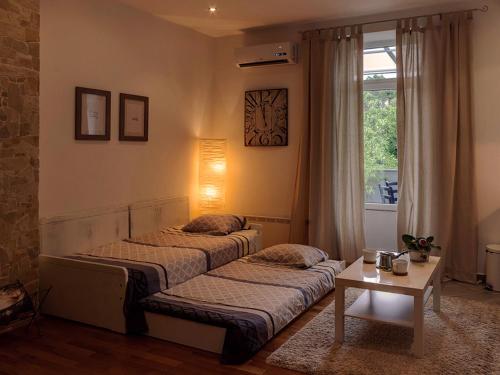 Charming Apartment في زغرب: غرفة نوم بسريرين وطاولة ونافذة