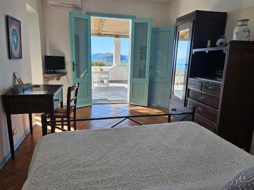 a bedroom with a bed and a desk and a television at Villa Paradiso - spectacular sea view over volcanoes in Piano Conte