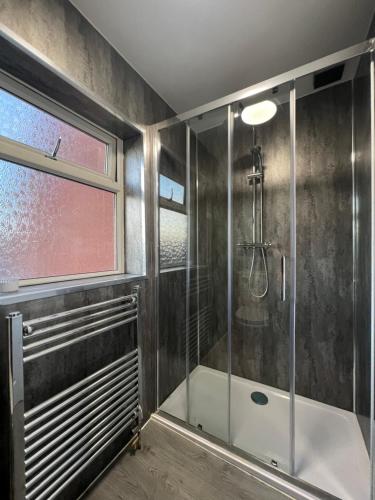 a bathroom with a shower with a glass door at Stylish Central Kettering Apartment by SJP in Kettering