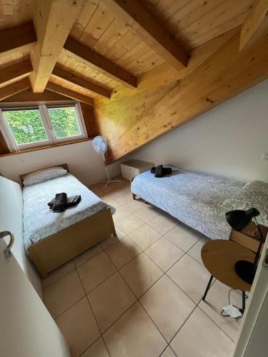 a bedroom with two beds and a wooden ceiling at Casa da Matti in Gravedona