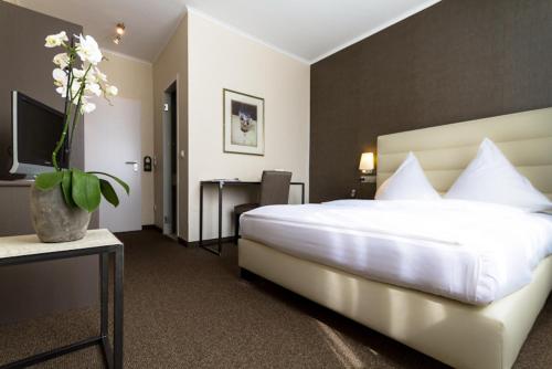 En eller flere senge i et værelse på Hotel Fischerhaus