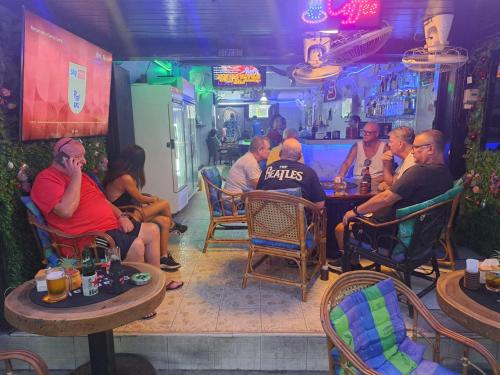 a group of people sitting at a bar at Scandalic Bar and Guest house in Pattaya