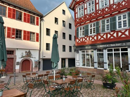 an outdoor patio with tables and chairs and buildings at CloudCabins Dornstetten - Marktplatz in Dornstetten