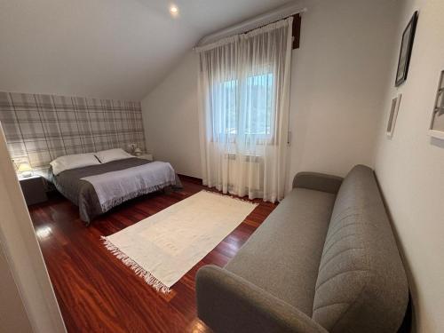 a living room with a couch and a bed at El Chalet Del Golf in Urturi