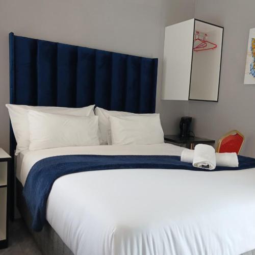 a bedroom with a large bed with a blue headboard at Likhanyile Guest Lodge in Nhlangano