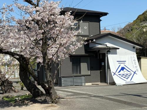 a tree in front of a house with a sign on it at Kamakura Hachiman Shrine Hotel 鎌倉八幡宮ホテル in Kamakura