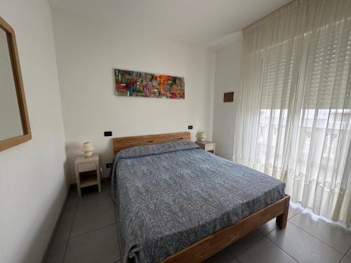 a bedroom with a bed and a painting on the wall at Appartamenti al Cigno in Lignano Sabbiadoro
