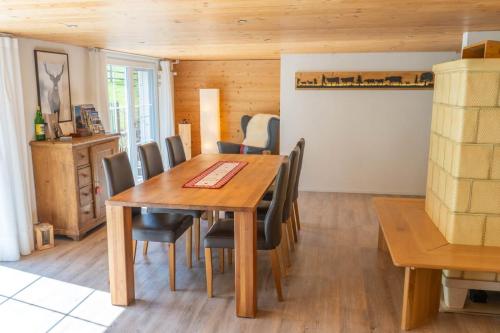 a dining room with a wooden table and chairs at Ferienhaus Hörli in Sankt Peterzell
