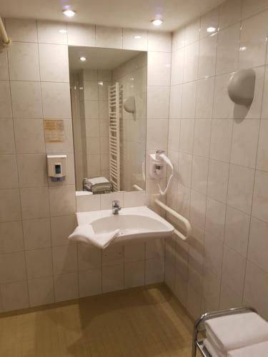 ein Bad mit einem Waschbecken und einem Spiegel in der Unterkunft Hotel Restaurant Anders in Schwarzenbruck