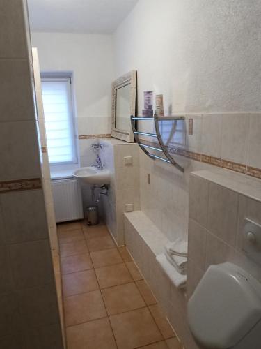 a white bathroom with a sink and a toilet at Familienfreundliche Fewo mit Garten in Schwarz