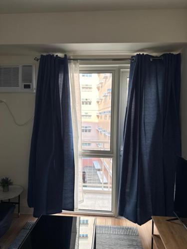 a window with blue curtains in a room at Rito in Jalang