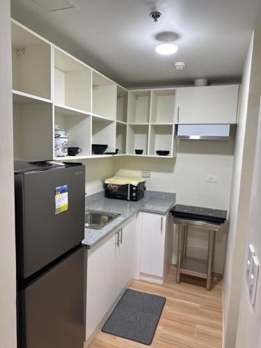 a kitchen with white cabinets and a black refrigerator at Rito in Jalang