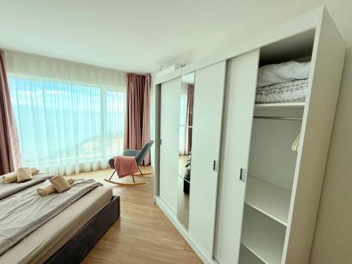 a bedroom with a bed and a large window at Apartment Sunrise Pomorie in Pomorie