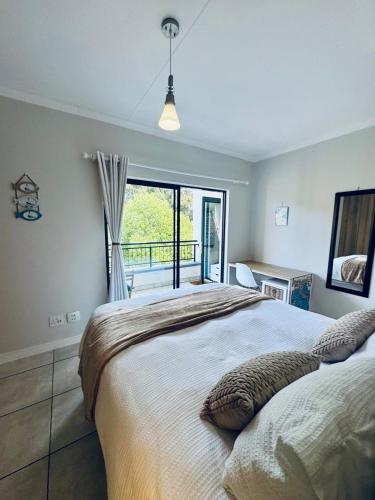 a bedroom with a large bed and a balcony at The Zhen in Strand