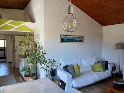 a living room with a white couch with green pillows at Casa Avezza in Omegna