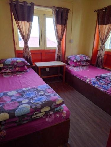 a room with two beds and a window at Fast food in Lukla