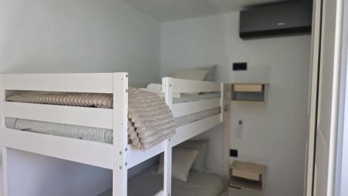 a white bunk bed in a room with a mirror at Casa TataDora in Arucas