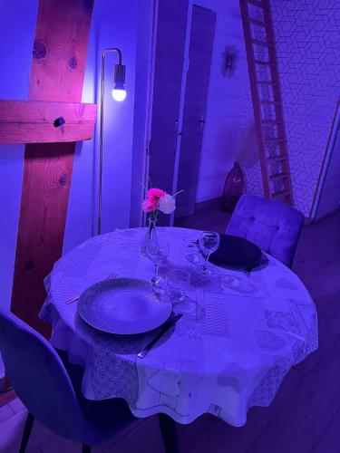 a table with a vase with a flower on it at La Suite Etoilée - Balnéo privative in Courgains