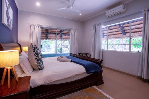 a bedroom with a large bed and a window at Kingfisher Creek Safari Cottages in Hoedspruit