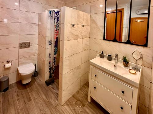 a bathroom with a sink and a shower and a toilet at Patio Suite in Olhão