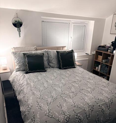 a bedroom with a large bed with black pillows at The Snug Guestroom Poole in Poole