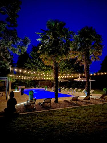 a person sitting next to a swimming pool at night at La Mancha Hall Stately Home in Halsall