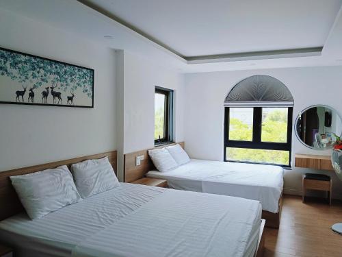 a hotel room with two beds and a window at Ruby Homestay in Cam Lâm