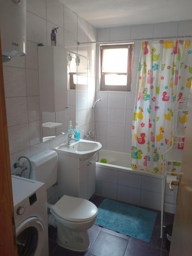 a bathroom with a toilet and a sink and a shower curtain at Guesthouse Behar in Sarajevo