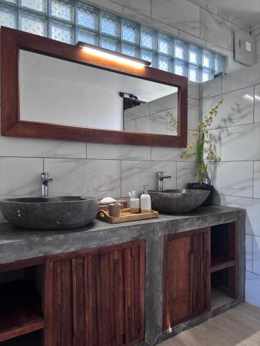 a bathroom with two sinks and a mirror at Gumi Ayu EcoStay in Munduk