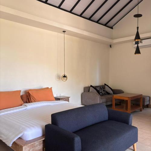 a bedroom with a bed and a couch at Gumi Ayu EcoStay in Munduk
