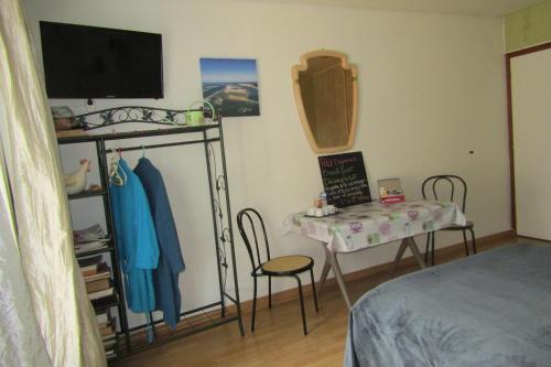 a bedroom with a table and a bed and a table and chairs at Galinat in Culmont
