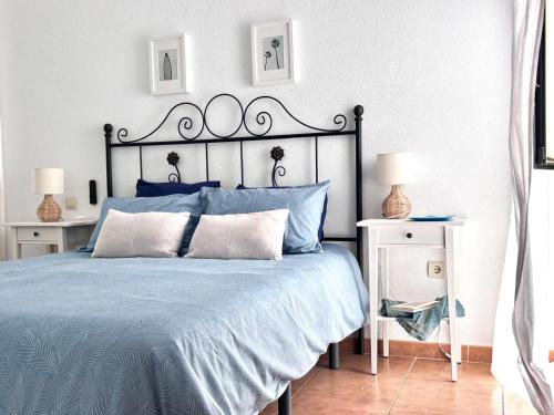 a bedroom with a blue bed with two night stands at Vitamin Sea in Zahara de los Atunes