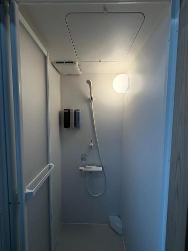 a bathroom with a shower with a light on the ceiling at Retreat 舞月 in Tanabe