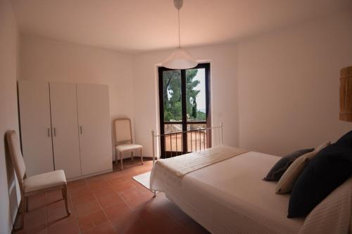 a bedroom with a bed and a window and a chair at Villa Fornaci - Marina di Campo in Marina di Campo