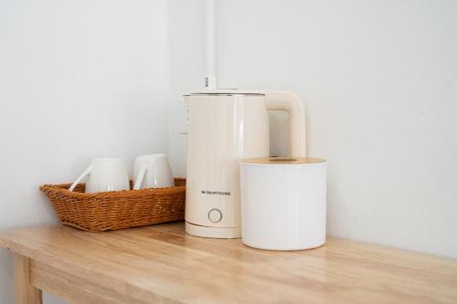 a white blender and a basket on a wooden table at Palai House in Ban Na Bon