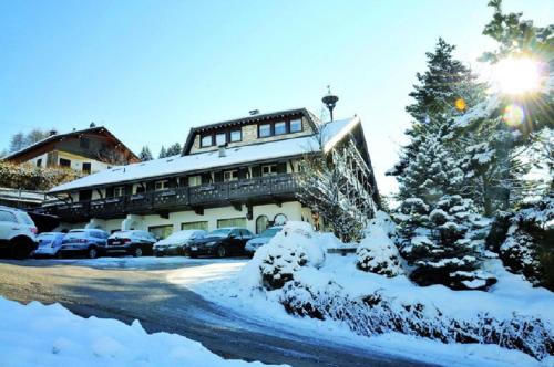 a snow covered building with cars parked in a parking lot at Hotel Villa Wilma in Folgaria