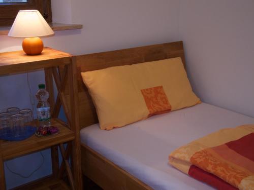 a bedroom with a bed with a pillow and a lamp at Atelier Reinhart in Rauhenebrach
