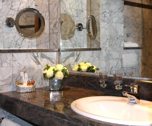ein Bad mit einem Waschbecken und einem Spiegel in der Unterkunft Hotel Hubertushof in Ibbenbüren