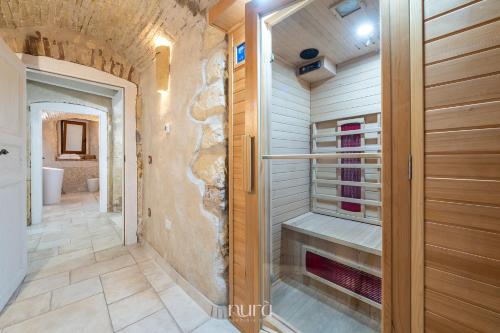 a bathroom with a walk in shower and a walk in closet at Castello Room & Spa in Cagliari