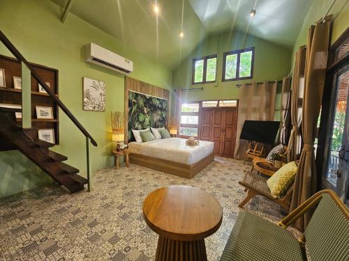 a living room with a bed and a table at Three Hen Lakeside in Ban Na Nai