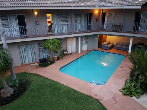 a swimming pool in the courtyard of a building at Loerie Guesthouse in Hoedspruit