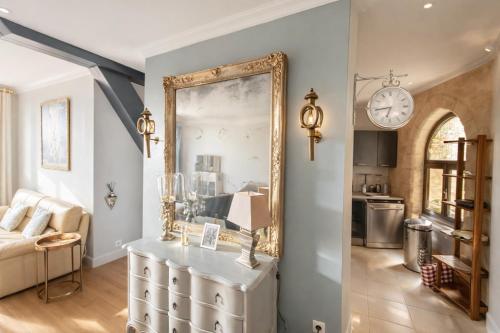 a living room with a mirror and a couch at La Salamandre - Un écrin médiéval pour vos souvenirs - Imaginez-vous, réveillé par le murmure de Sarlat, dans un appartement spacieux et chaleureux, au cœur de la Cité classée - 2 chambres - Une magie à vivre sans modération - Réservez dès maintenant ! in Sarlat-la-Canéda