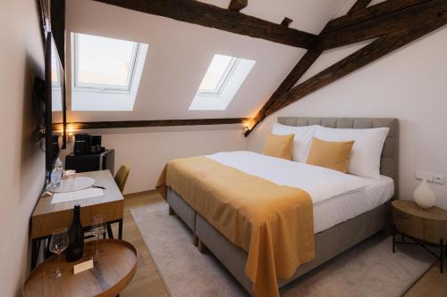 a bedroom with a king sized bed and a table at Maison Kounic Palace Suites in Slavkov u Brna
